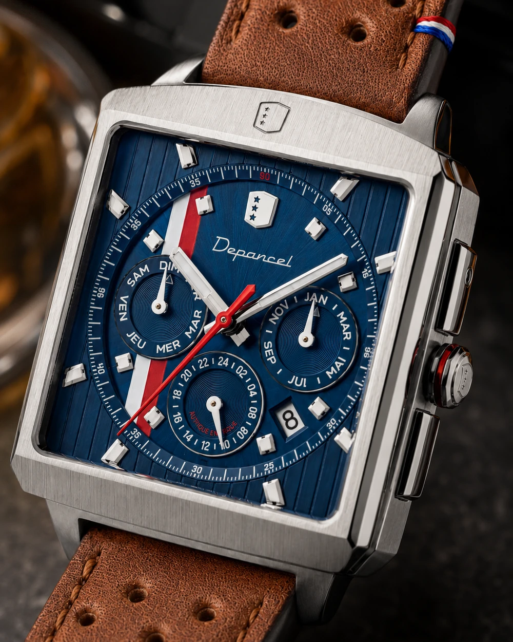 Macro du calendrier, du boîtier en acier et du bracelet en cuir d’une montre automatique rectangulaire
