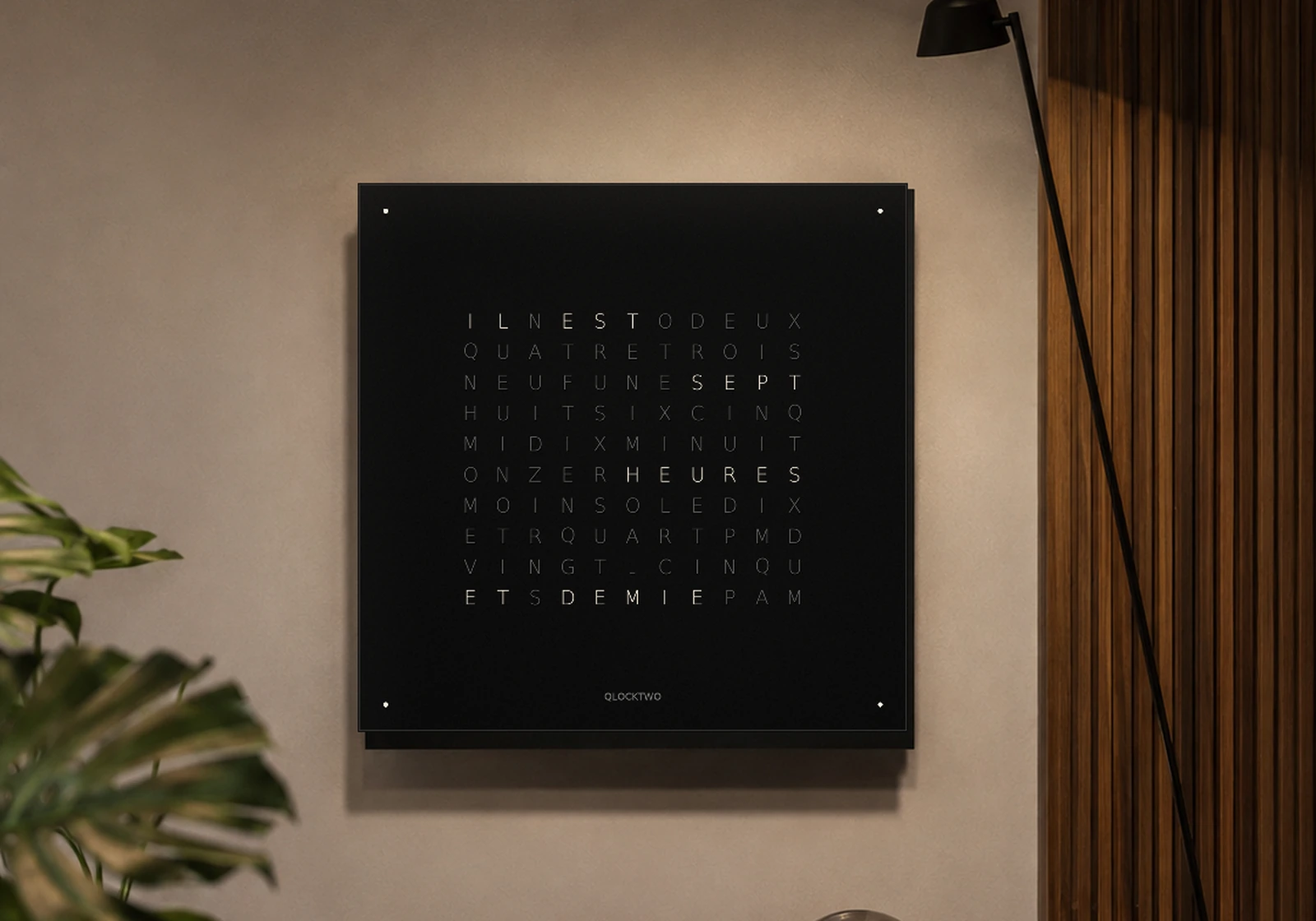 Horloge carrée noire affichant l’heure en toutes lettres françaises dans un salon contemporain